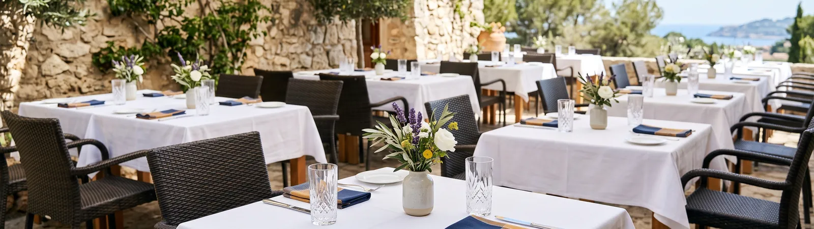 Gedeckte Tische auf einer sonnigen Restaurantterrasse